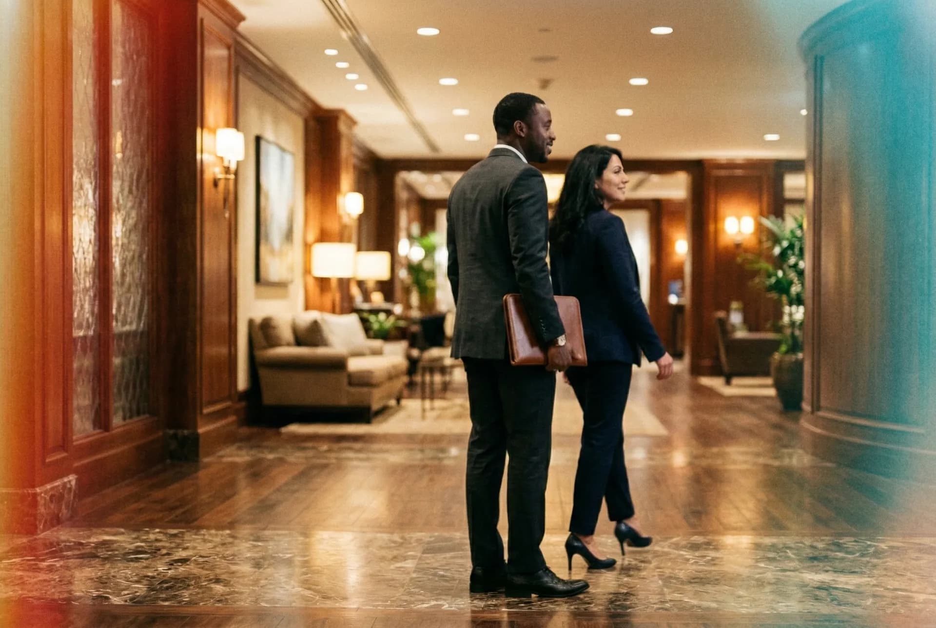 Two colleagues walking together through an office lobby